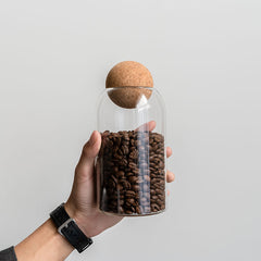 Cork lid lifted from a jar of coffee beans, ready to scoop