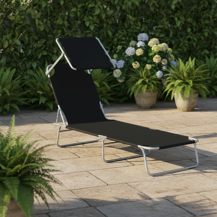 Nestora folding lounger on a patio, a cold drink and paperback within reach
